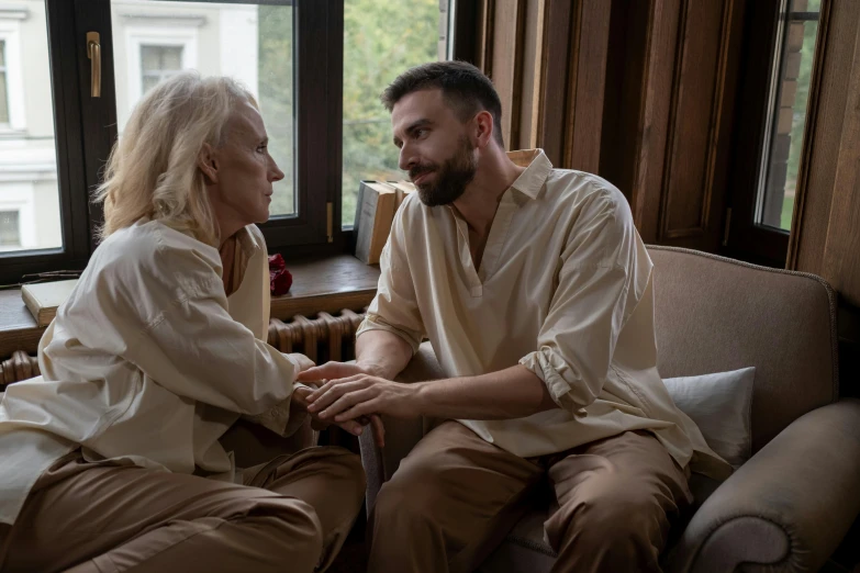 a man and a woman sitting on a couch, by Emma Andijewska, pexels contest winner, renaissance, older woman, holding each other hands, handsome man, ( ( theatrical ) )