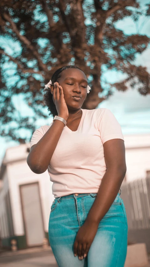 a woman talking on a cell phone next to a tree, an album cover, by Stokely Webster, trending on pexels, happening, wearing a light blue shirt, pink headphones, 15081959 21121991 01012000 4k, brown skin