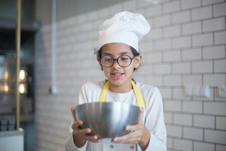 a little girl in a chef's hat holding a bowl, pexels contest winner, mia khalifa, aged 13, avatar image, bakery