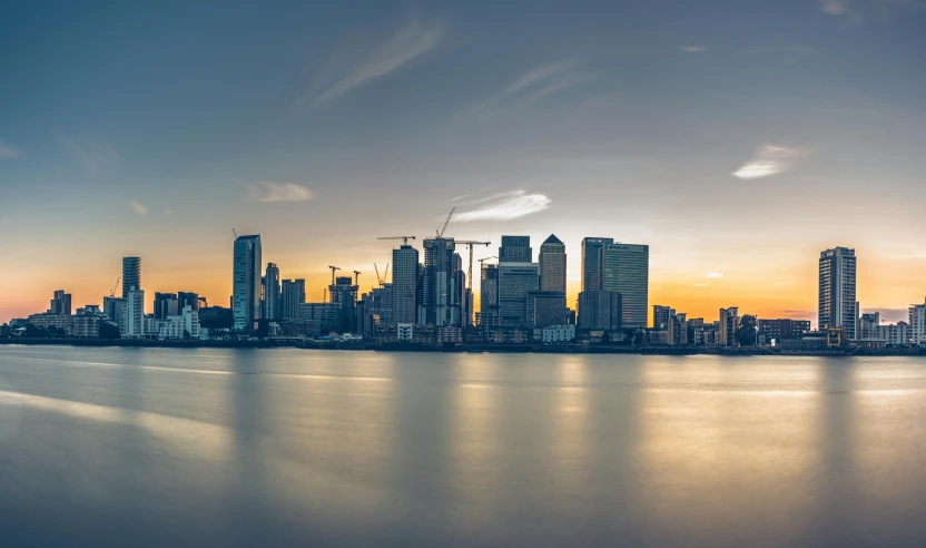 a large body of water with a city in the background, pexels contest winner, hyperrealism, canary wharf, sunset panorama, 8k resolution”, group photo