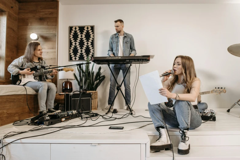 a group of people sitting on top of a white counter, an album cover, trending on pexels, singing into microphone, christian cline, living room vibe, background image