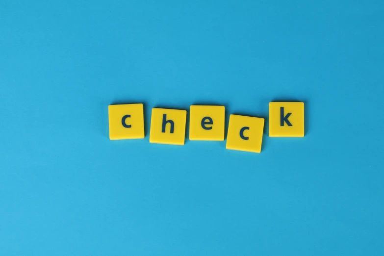 the word check spelled in scrabbles on a blue background, by Emma Andijewska, yellow backdrop, inspect in inventory image, pregnancy, nfts