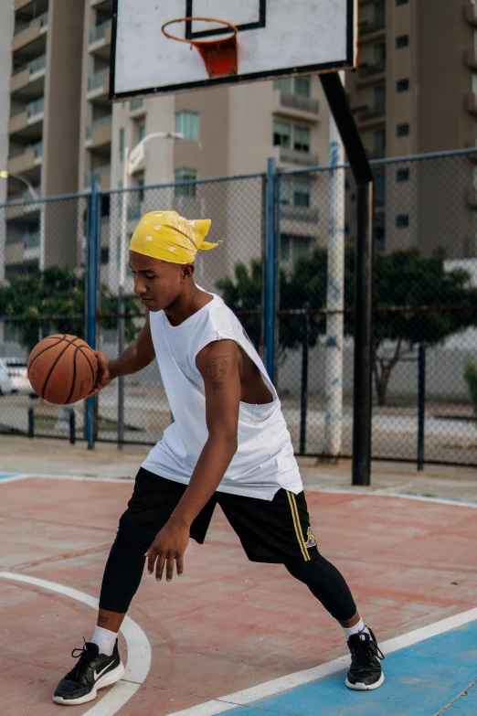 a man standing on top of a basketball court holding a basketball, trending on dribble, gang saints wear yellow bandanas, sao paulo, in an action pose, wearing a headband