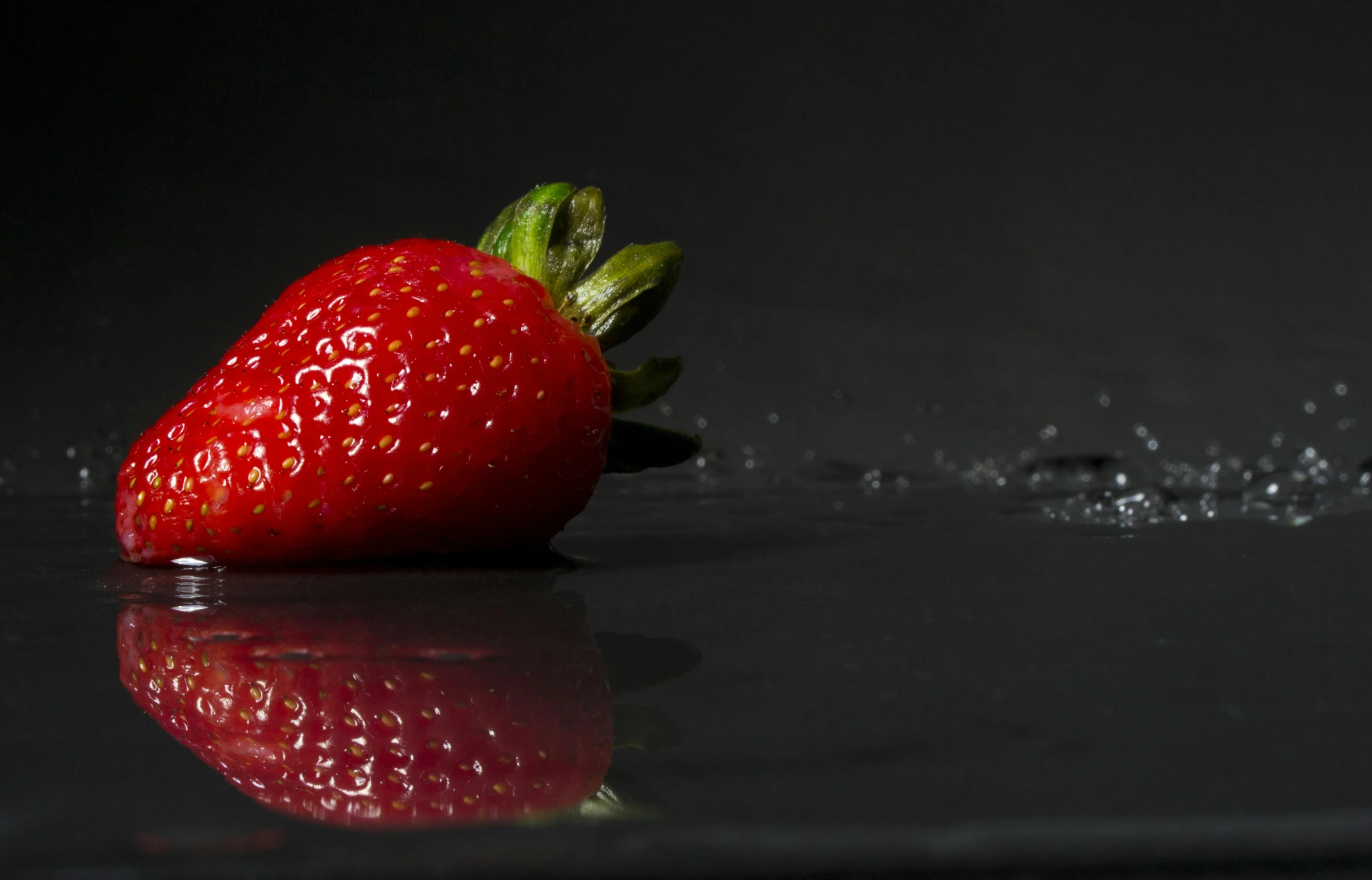 a close up of a strawberry on a black surface, thumbnail, fan favorite, glossy surface, distant photo