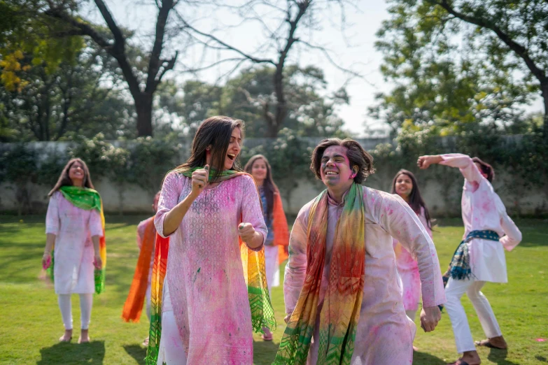 a group of women standing on top of a lush green field, an album cover, gutai group, dressed in a jodhpuri suit, wearing rainbow kimono, tie-dye, shot with sony alpha