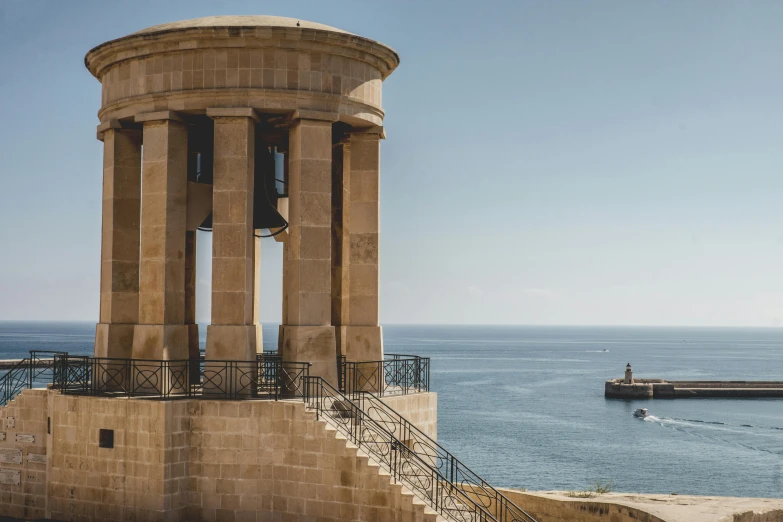 a clock tower sitting next to a body of water, by Simon Marmion, pexels contest winner, neoclassical tower with dome, view of sea, classical stone columns, slide show