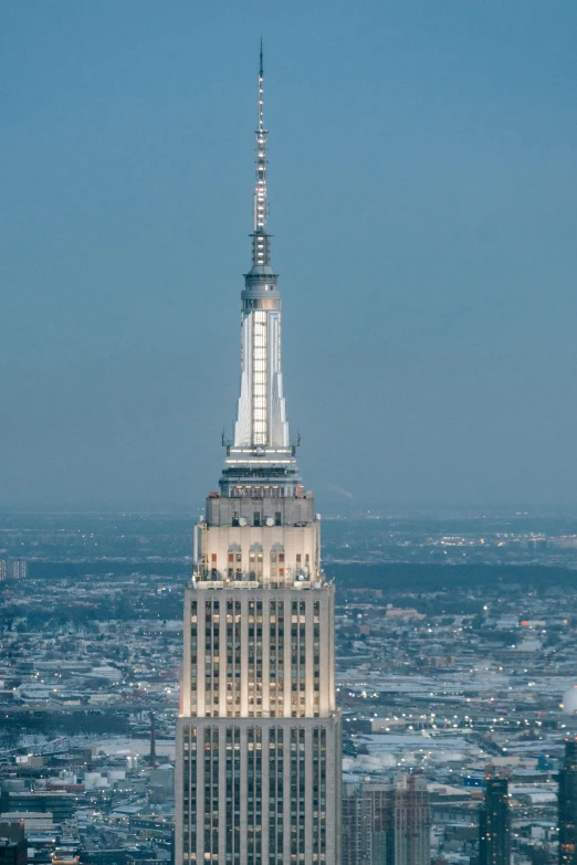 a very tall building in the middle of a city, empire state building, zoomed out to show entire image, february), lead - covered spire