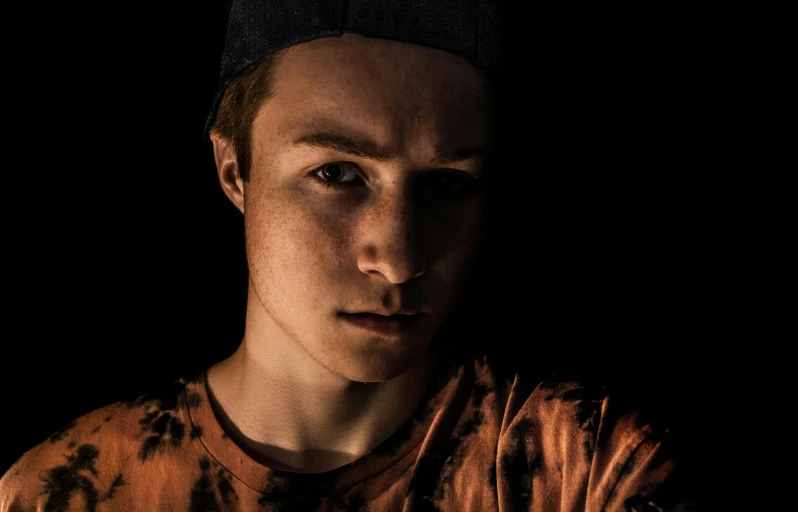 a close up of a person wearing a tie dye shirt, a character portrait, pexels contest winner, lowkey lighting, teenage boy, portrait of a slightly rusty, dramatic serious pose
