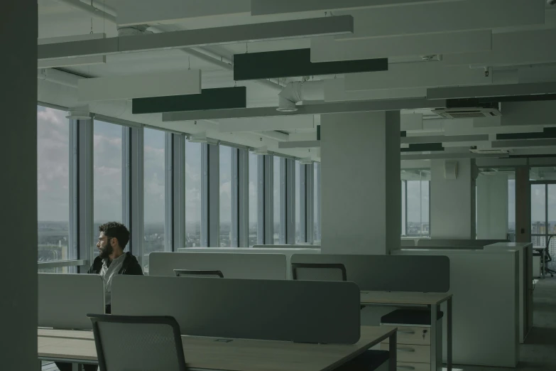 a man sitting at a desk in an office, inspired by David Chipperfield, renaissance, up there, worksafe. cinematic, the panorama, solitude