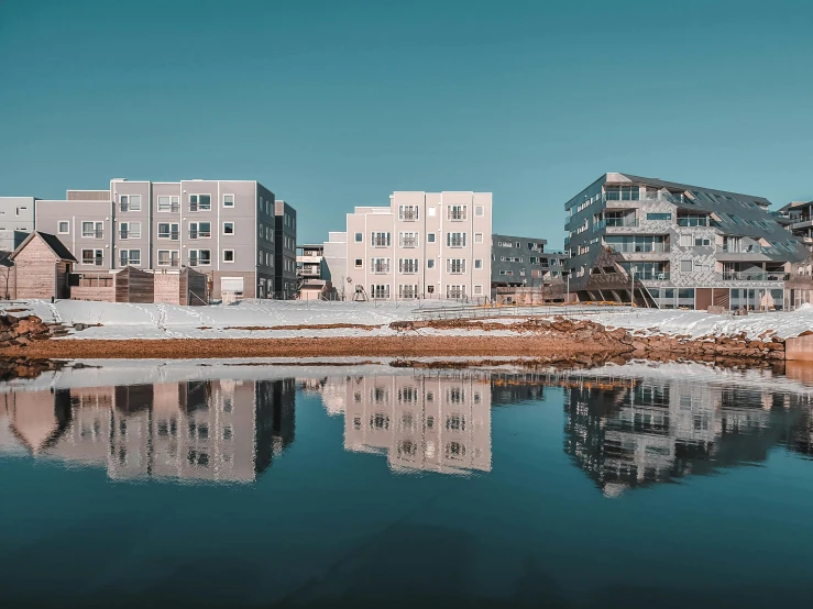 a body of water with buildings in the background, by Sven Erixson, pexels contest winner, hyperrealism, in a suburb, symmetrical shot, reykjavik junior college, full of clear glass facades