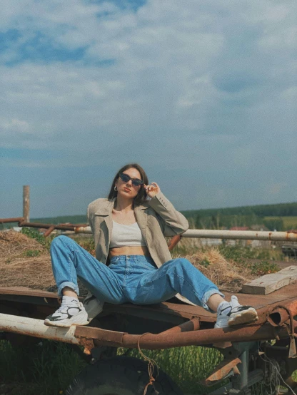 a woman sitting on the back of a tractor, a picture, by Attila Meszlenyi, trending on pexels, aestheticism, baggy jeans, with sunglass, in russia, vhs style