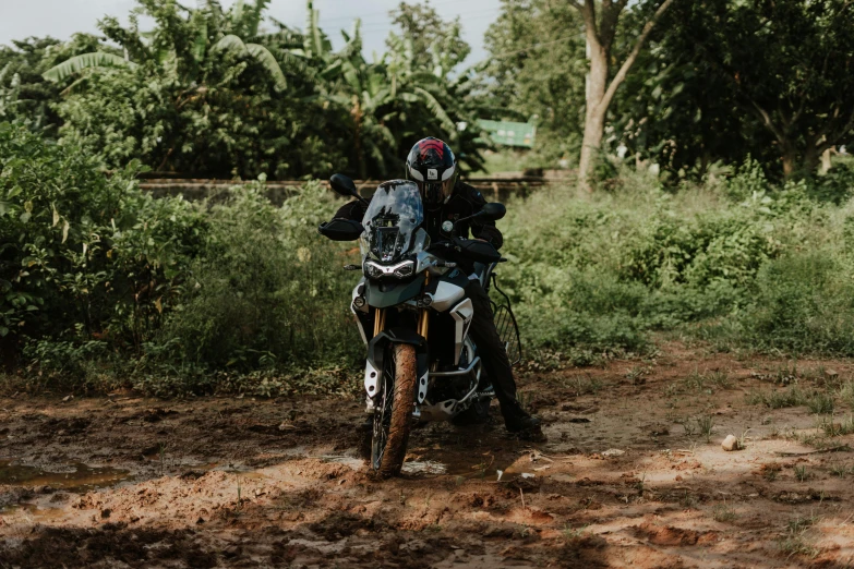 a person riding a motorcycle on a dirt road, pexels contest winner, jungles in the background, avatar image, fully armoured, close-up photo