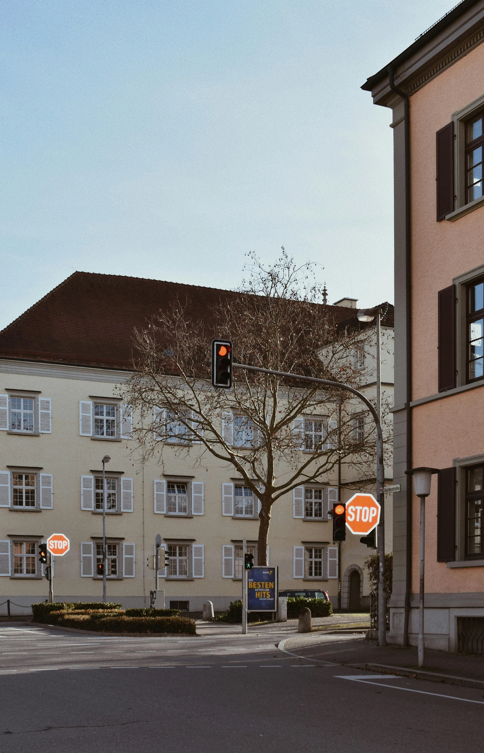 a red stop sign sitting on the side of a road, an album cover, heidelberg school, white marble buildings, traffic signs, overview, with orange street lights