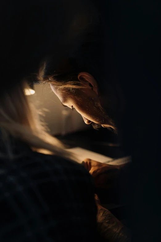 a man reading a book in the dark, pexels contest winner, light and space, woman's face looking off camera, scratches on photo, a woman's profile, sunlit