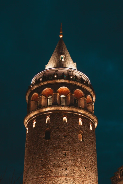 a tall clock tower lit up at night, inspired by Altoon Sultan, trending on pexels, hurufiyya, cone shaped, spiral, portait photo, preserved historical