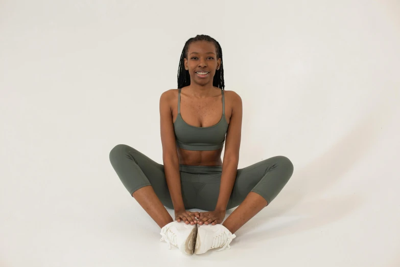 a woman sitting on the floor with her legs crossed, hurufiyya, pixel stretching, sage green, ebony skin, clear background