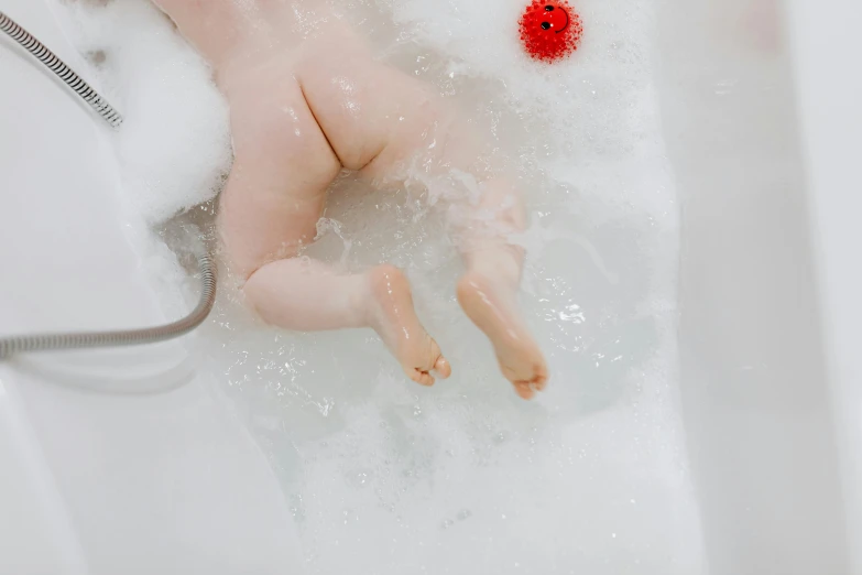 a doll that is laying in a bath tub, by Julia Pishtar, pexels, extra fleshy hands, foamy bubbles, easy to use, lachlan bailey