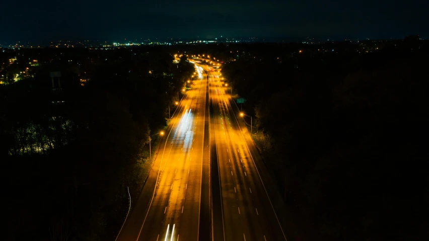 an aerial view of a highway at night, unsplash, realism, yellow light, landscape photo, furious lights, wide open city ”