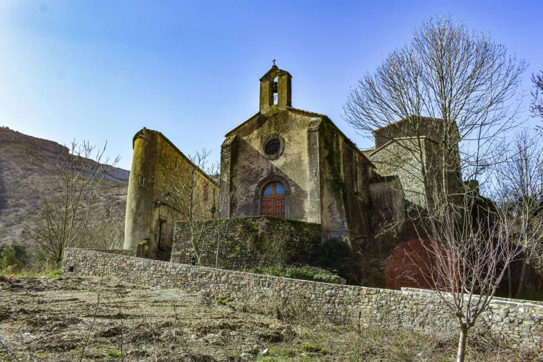 an old church sitting on the side of a hill, by Carlo Carrà, pexels contest winner, romanesque, 2 5 6 x 2 5 6 pixels, french village exterior, an abandonded courtyard, albert ramon puig