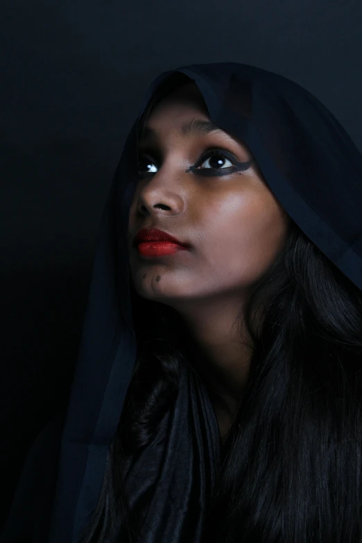 a woman with a hood over her head, inspired by Lily Delissa Joseph, pexels contest winner, dark complexion, studio portrait, dark lips, black cape