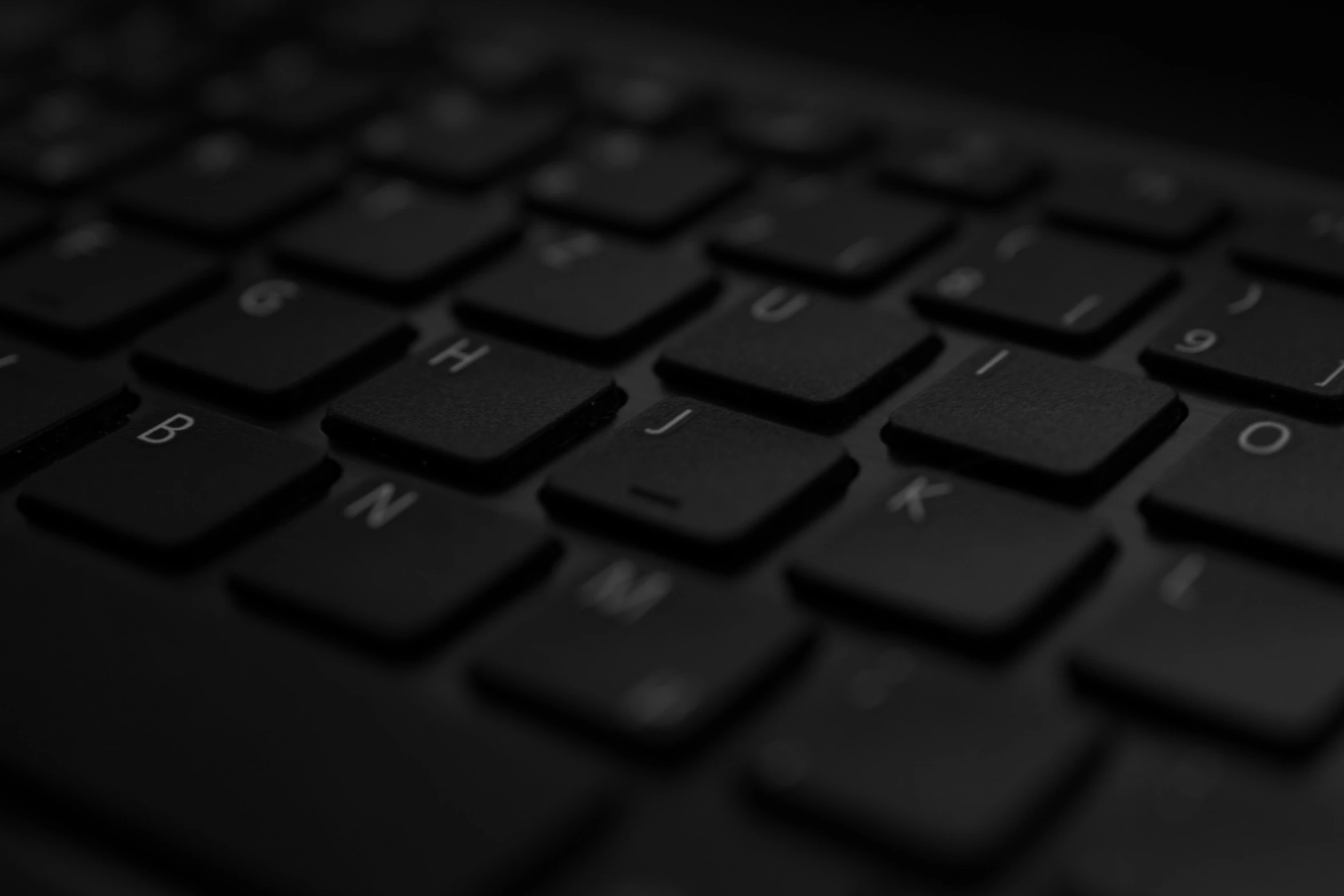a close up of a black computer keyboard, by Adam Marczyński, unsplash, computer art, background image, noir, typing on laptop, close-up photo