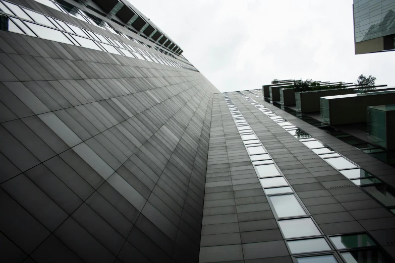 a black and white photo of a tall building, inspired by Tadao Ando, pexels contest winner, worm\'s eye view, view from the side, morphosis, tokyo futuristic and clean