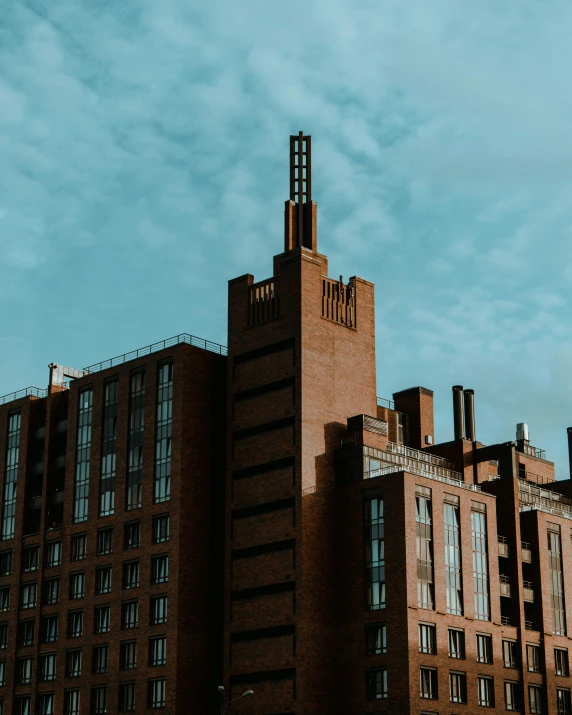 a tall brick building with a clock tower, inspired by Ricardo Bofill, pexels contest winner, manchester, apartment complex made of tubes, rule of thirds, chocolate city