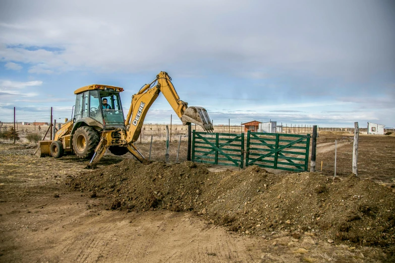 a tractor that is sitting in the dirt, large gate, drumheller, bioremediation, brown