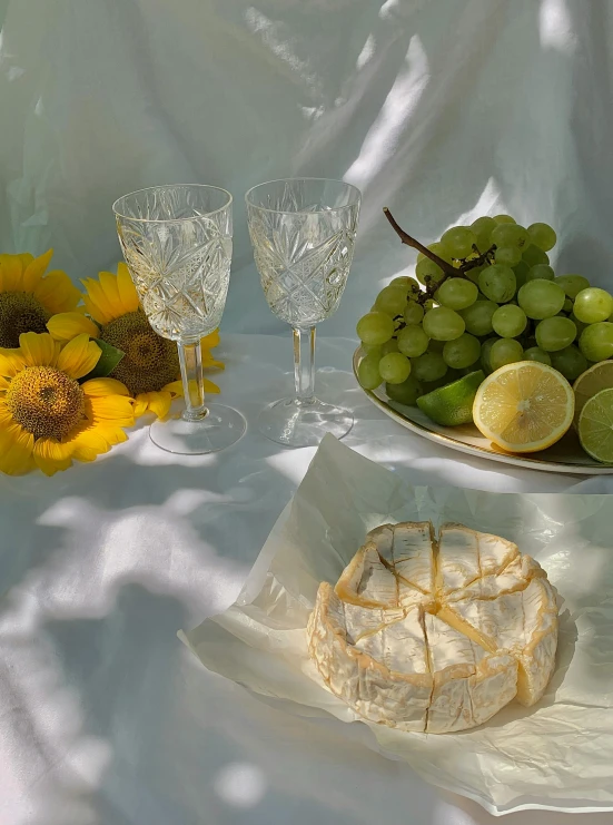 a table topped with plates of food next to sunflowers, inspired by Konstantin Somov, photorealism, translucent grapes, 🍸🍋, beautiful natural backlight, made of cheese