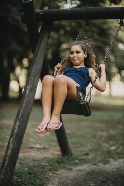 a girl sitting on a swing in a park, a portrait, pexels contest winner, cinestill 800t 50mm eastmancolor, isabela moner, slides, black