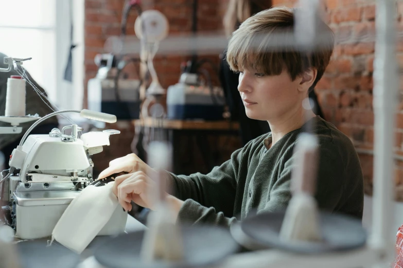 a woman working on a sewing machine in a factory, a portrait, trending on unsplash, teenage boy, paul barson, aged 13, avatar image