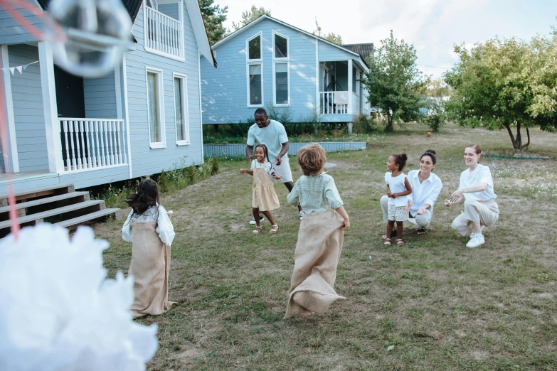 a group of people that are standing in the grass, cottage, harriet tubman skateboarding, sea - green and white clothes, cottagecore