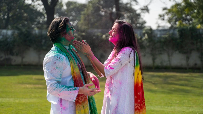 a couple of people that are standing in the grass, pexels contest winner, color field, wearing a silk kurta, splashes of colors, wearing white cloths, profile image
