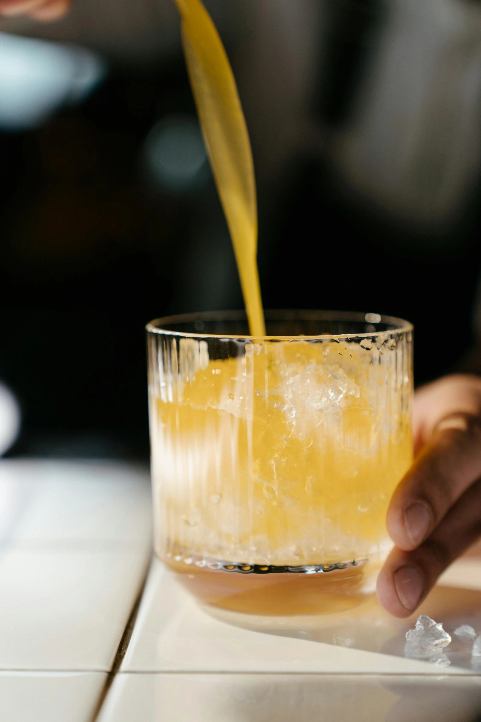 a person pouring orange juice into a glass, unsplash, renaissance, very smoky paris bar, whiskey glass with ice cubes, epicurious, uncrop