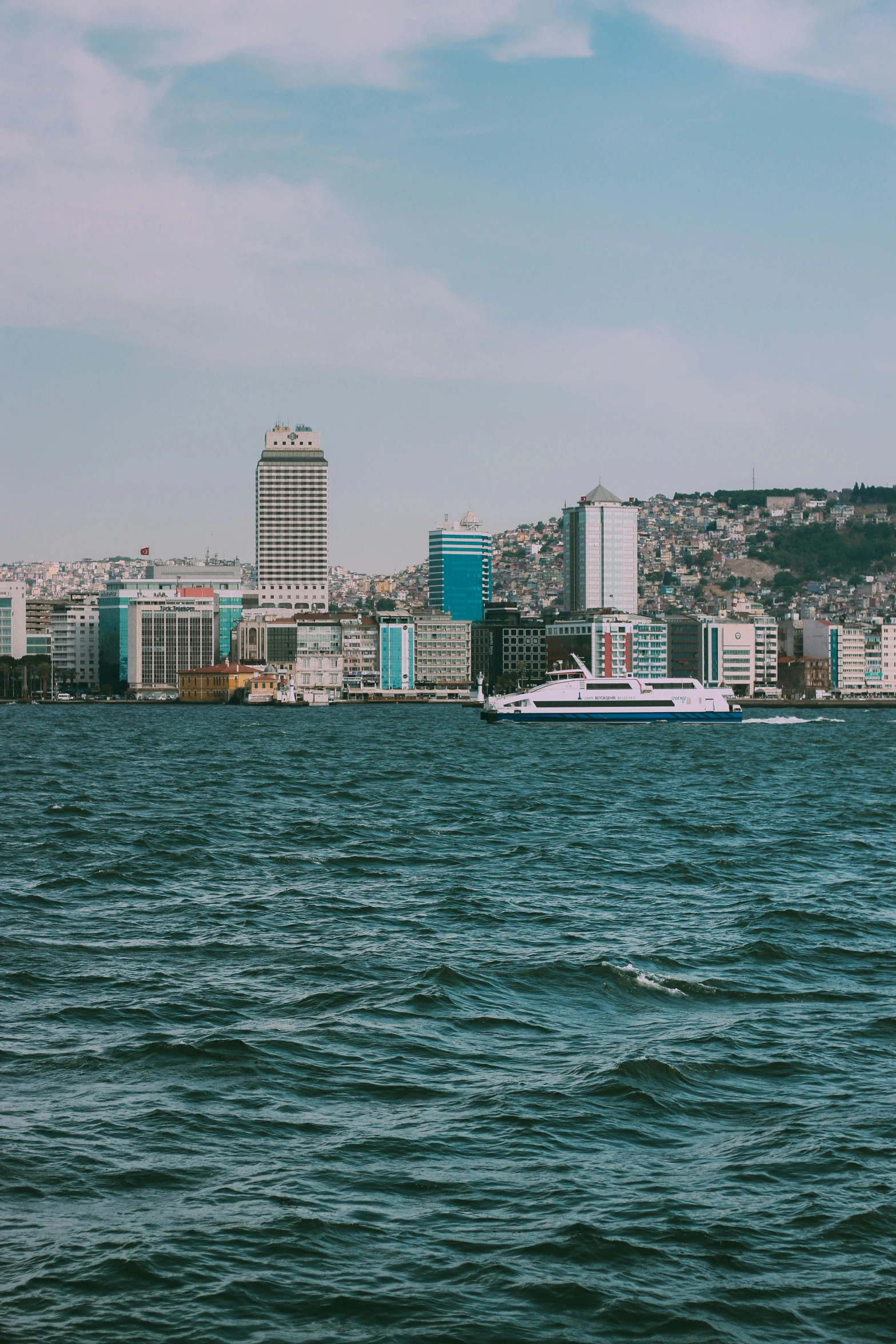 a boat in a body of water with a city in the background, inspired by Elsa Bleda, pexels contest winner, turkey, slide show, panorama view, large tall