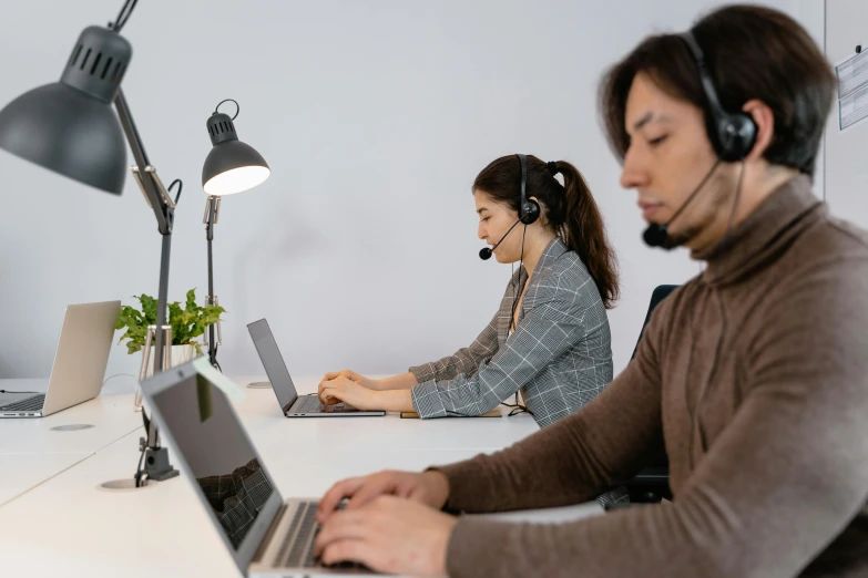 a couple of people sitting at a table with laptops, trending on pexels, hurufiyya, working in a call center, nishimiya shouko, thumbnail, background image