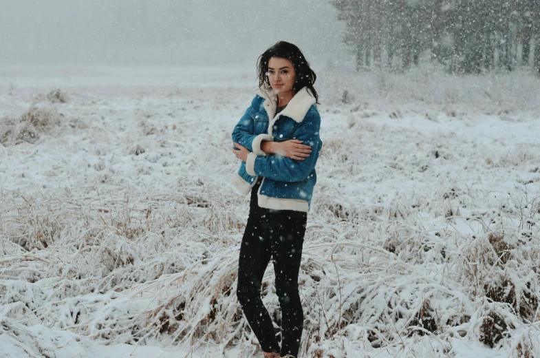 a woman standing in a snow covered field, inspired by Elsa Bleda, pexels contest winner, an aviator jacket and jorts, wearing festive clothing, brunette, instagram picture