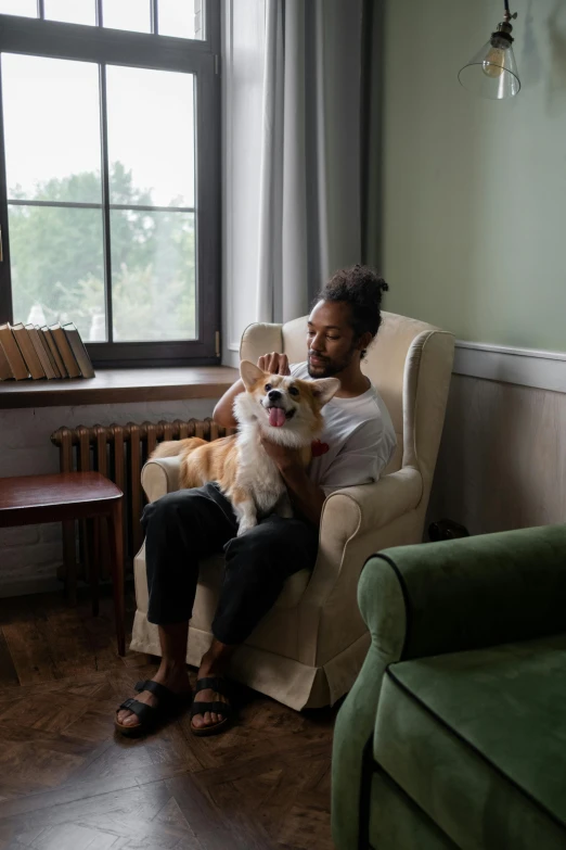 a woman sitting in a chair holding a dog, by Jakob Emanuel Handmann, pexels contest winner, attractive man, ashteroth, in a japanese apartment, gif