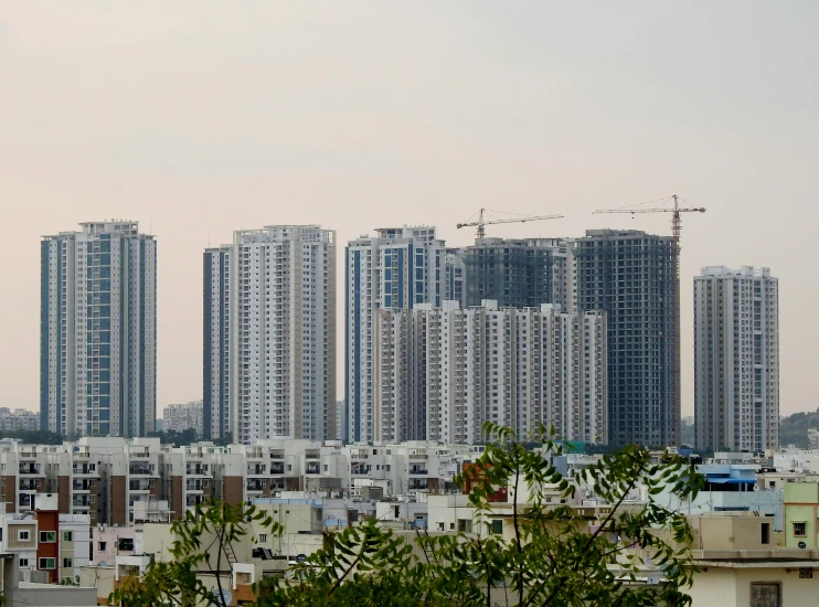 a view of a city with lots of tall buildings, by Joseph Severn, pexels contest winner, bauhaus, bangalore, greenery growing, construction, 2 0 0 mm wide shot