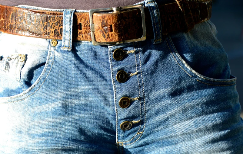a close up of a person wearing jeans and a belt, an album cover, pexels, hoog detail, steampunk clothes, daisy dukes, highly textured