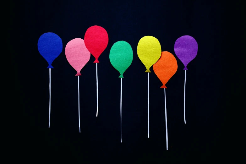 a row of multicolored balloons against a black background, by Alison Geissler, pexels, figuration libre, paper cutouts of plain colors, instagram post, felt, group of seven