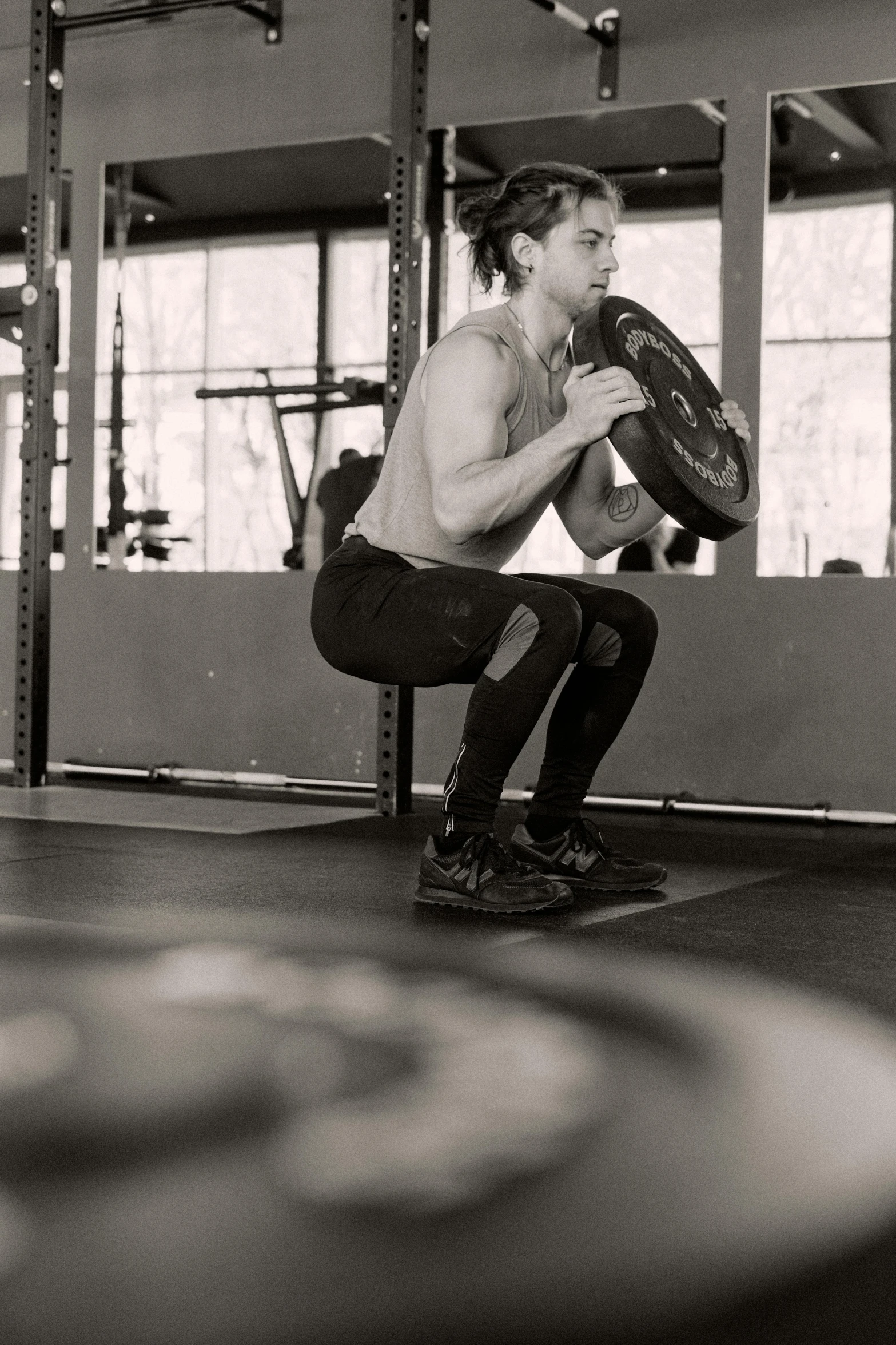 a man squatting with a barbell in a gym, a black and white photo, by Adam Marczyński, pexels contest winner, instagram story, caucasian, multi-part, they are crouching