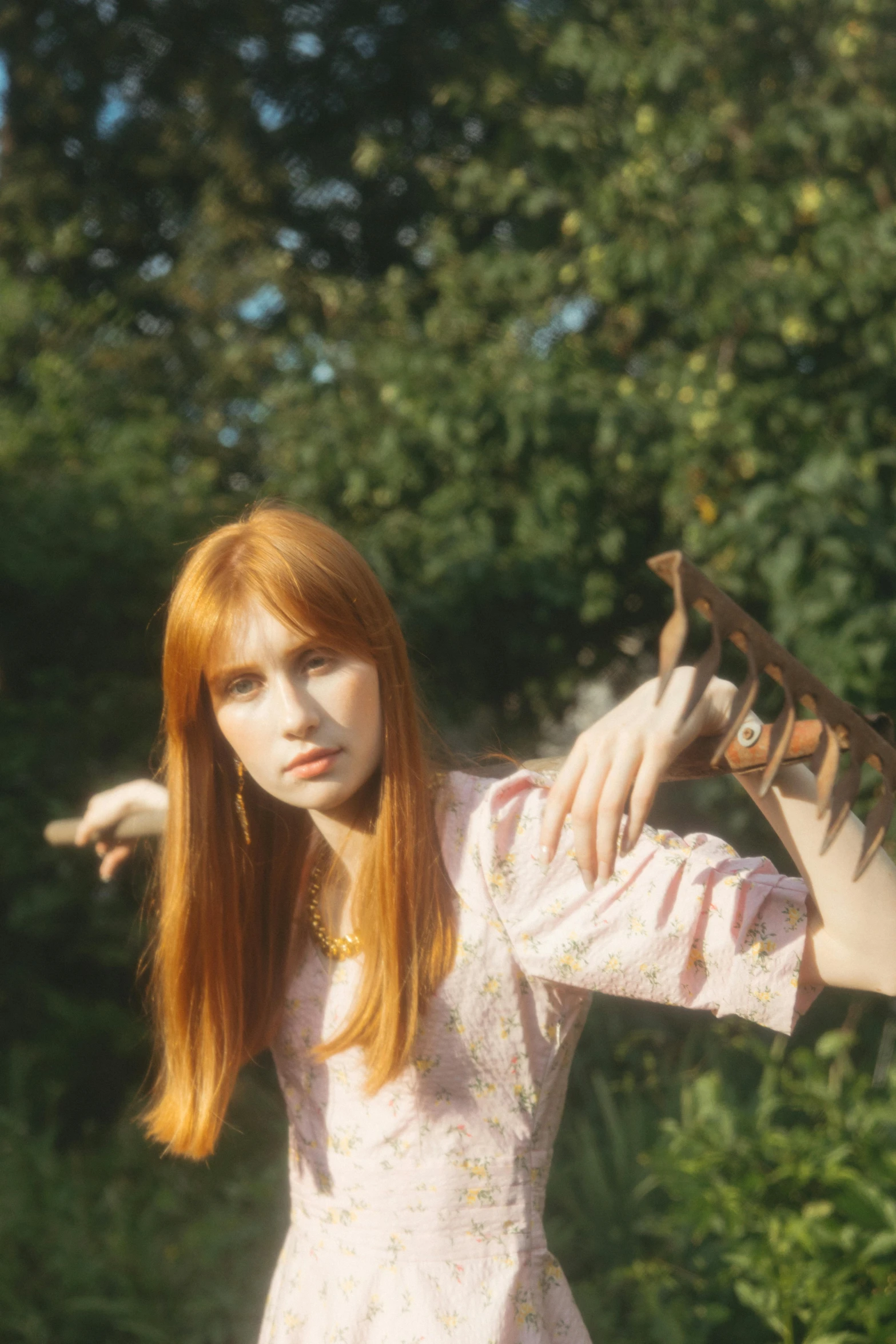 a woman in a pink dress holding a bird, an album cover, trending on pexels, she has long redorange hair, with a fringe, serpentine pose, taken in 1 9 9 7