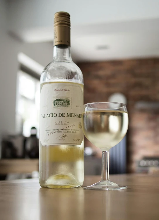 a bottle of wine and a glass on a table, inspired by Pablo Munoz Gomez, pexels contest winner, a very macular woman in white, mead, high quality product image”, frontal shot