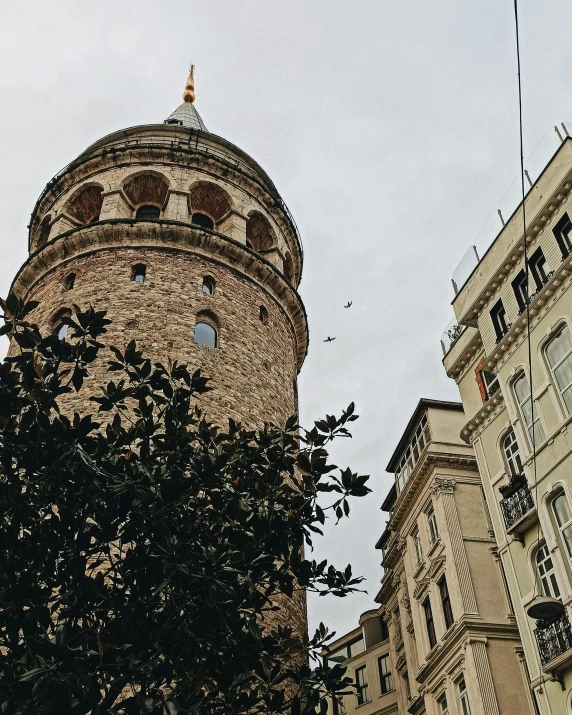 a tall tower sitting in the middle of a city, by Lucia Peka, pexels contest winner, art nouveau, ottoman sultan, lgbtq, thumbnail, low quality grainy