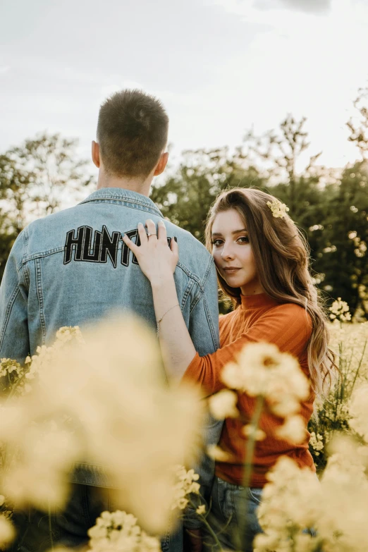 a man and woman standing in a field of flowers, an album cover, pexels contest winner, hurufiyya, wearing a jeans jackets, hunter hunter, handsome girl, honest