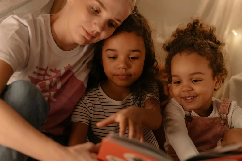 a woman reading a book to two children, pexels contest winner, avatar image, night time footage, diverse ages, close up portrait shot