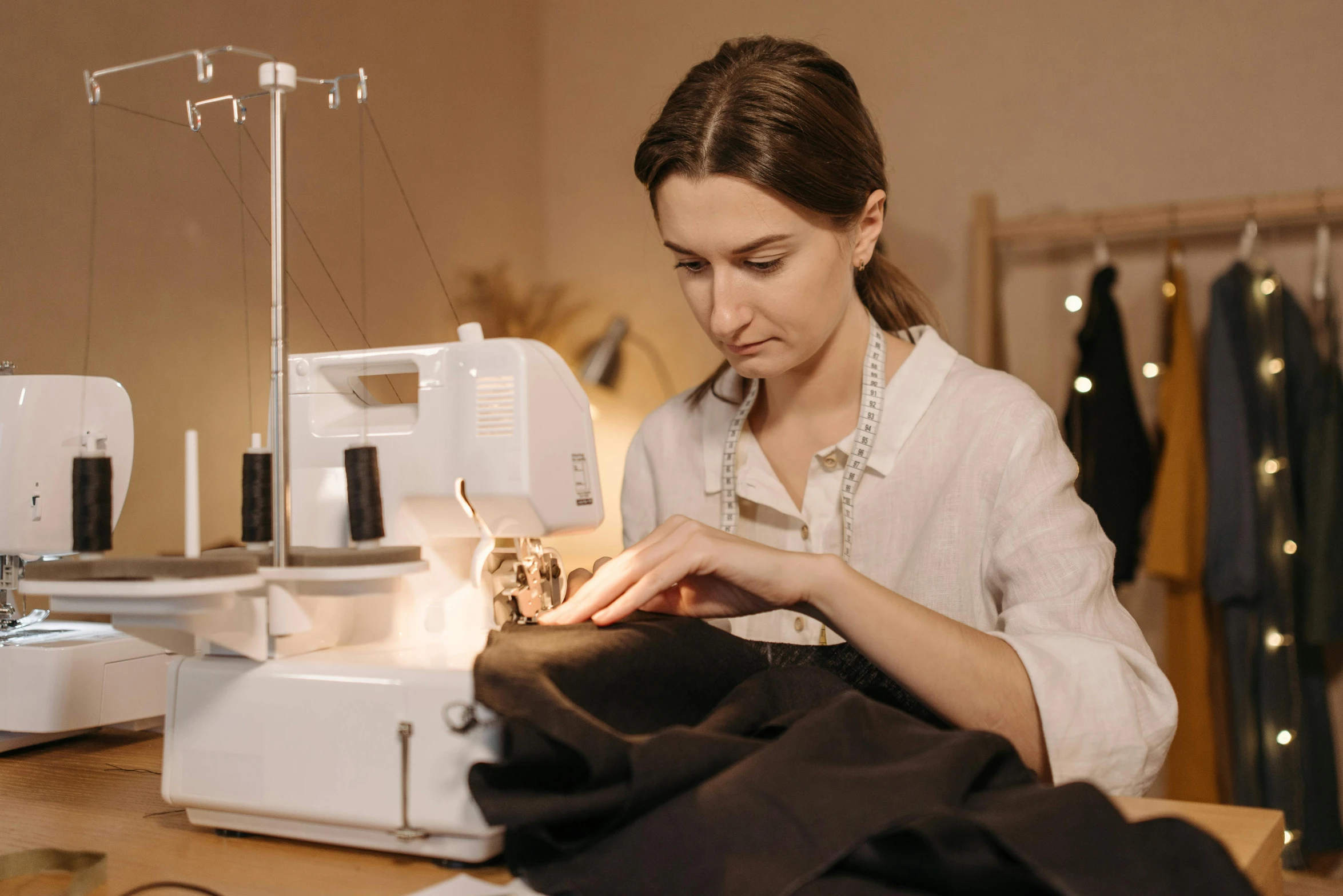 a woman is working on a sewing machine, a portrait, by Julia Pishtar, pexels contest winner, wearing black vest and skirt, avatar image, maintenance, brown