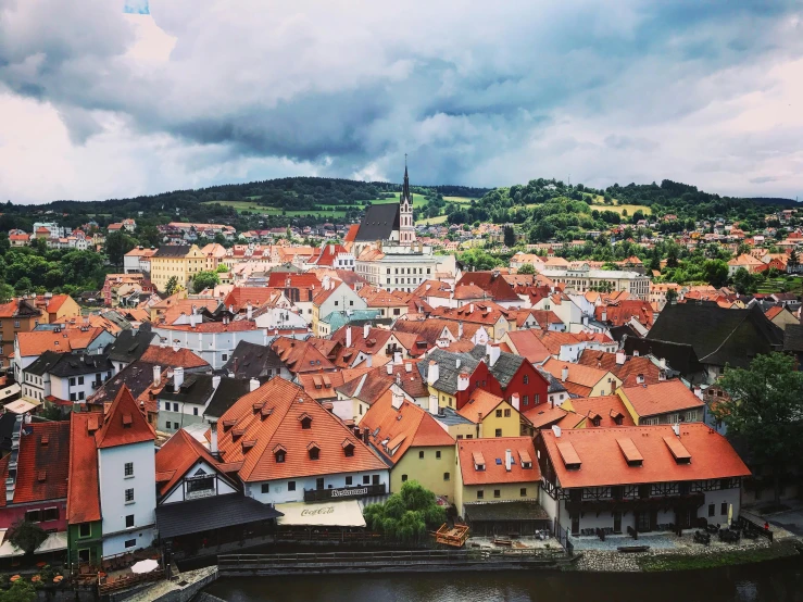 a view of a town from the top of a hill, by Emma Andijewska, pexels contest winner, baroque, square, orange grey white, colorful”, 1990's photo