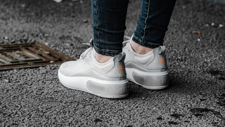 a close up of a person's shoes on the ground, inspired by Niko Henrichon, trending on pexels, altermodern, gradient white to silver, light grey crown, white and orange, woman in streetwear